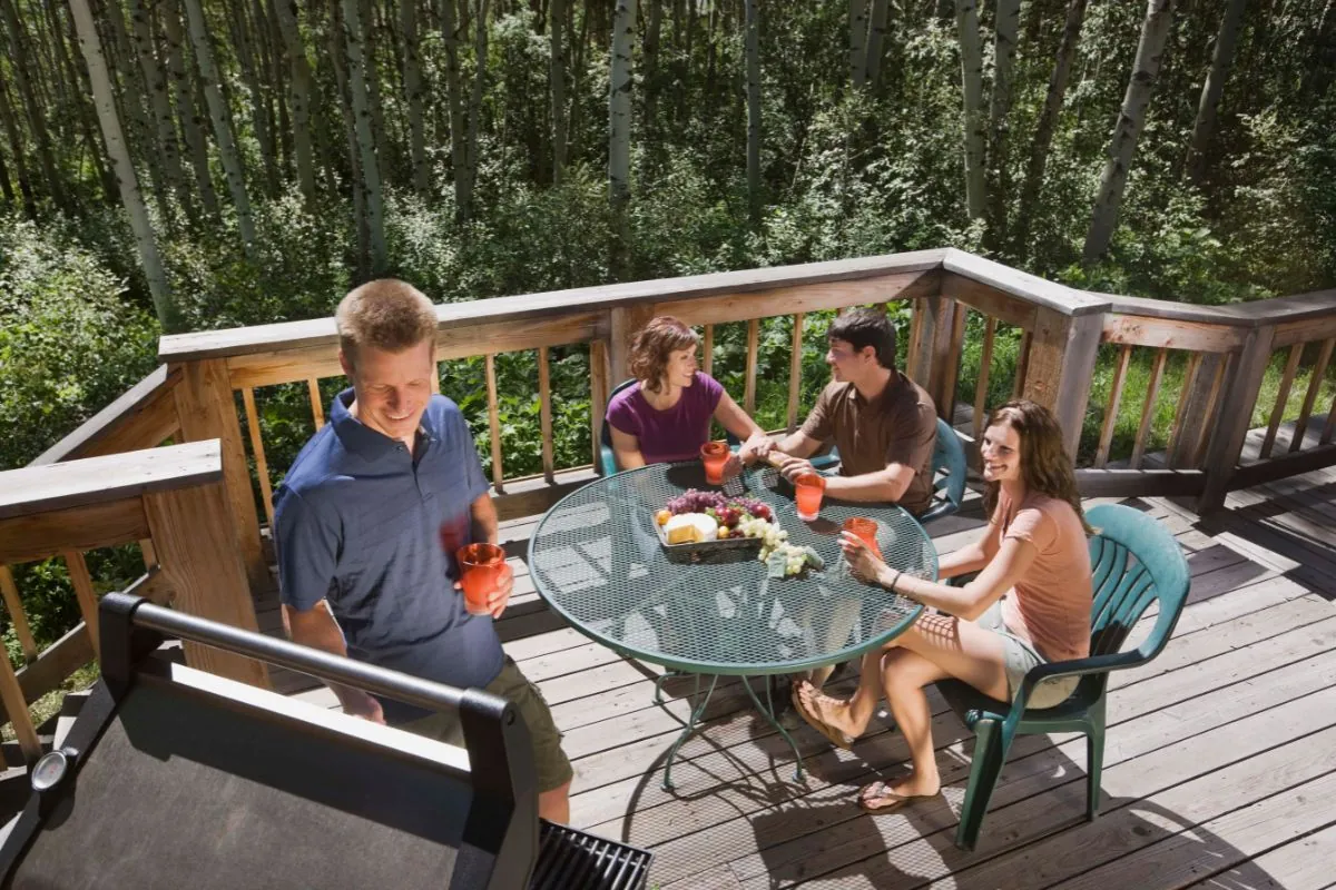 group of friends having barbecue at backyard deck