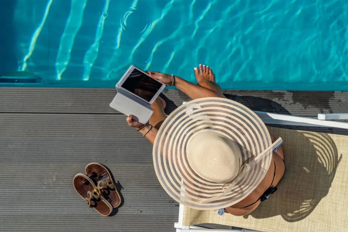 women using her phone by the poolside